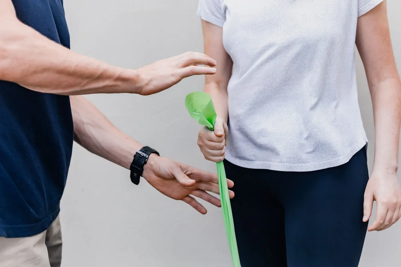 Therapeutin behandelt den Arm eines Patienten in einem hellen Raum
