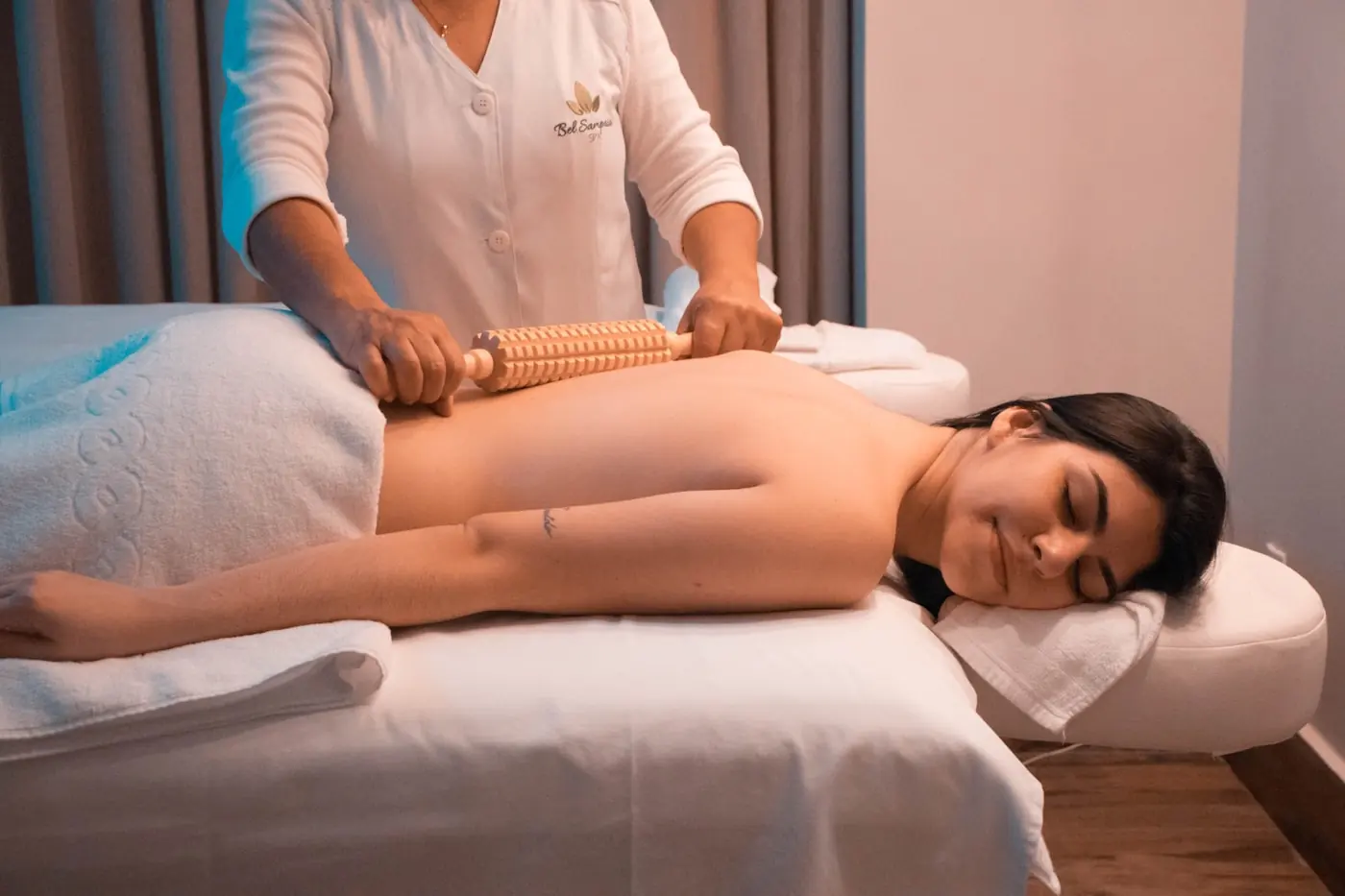 Masseurin behandelt den Rücken einer liegenden Person