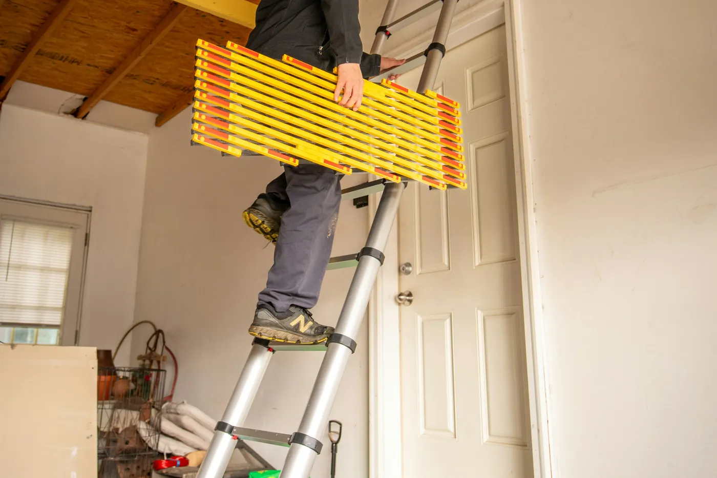 Maler auf der Leiter arbeitet am Türrahmen eines Wohnraums