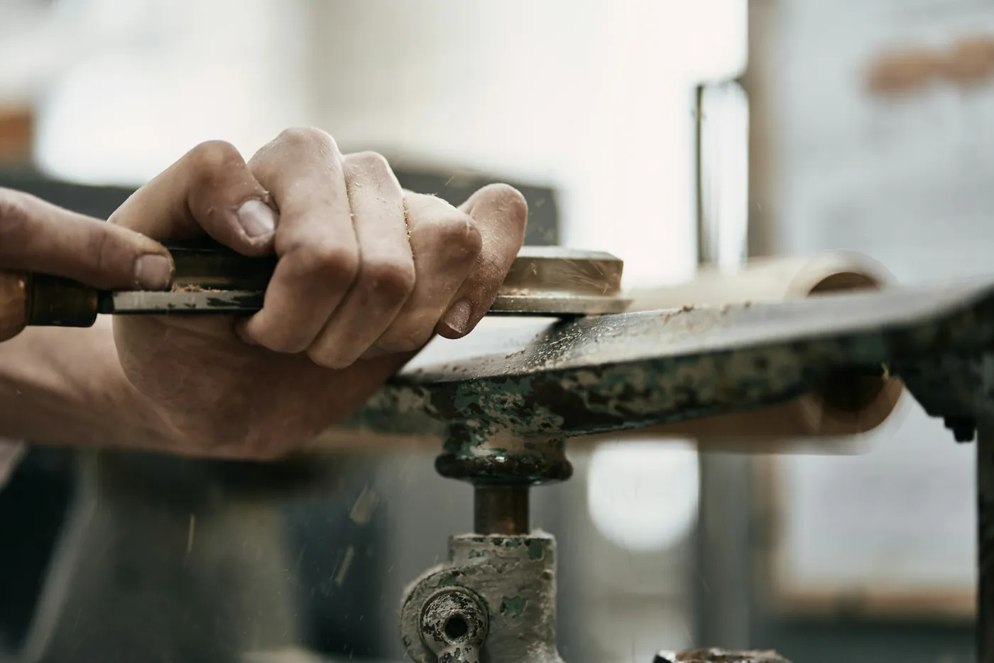 Hände formen ein Holzstück auf der Werkbank