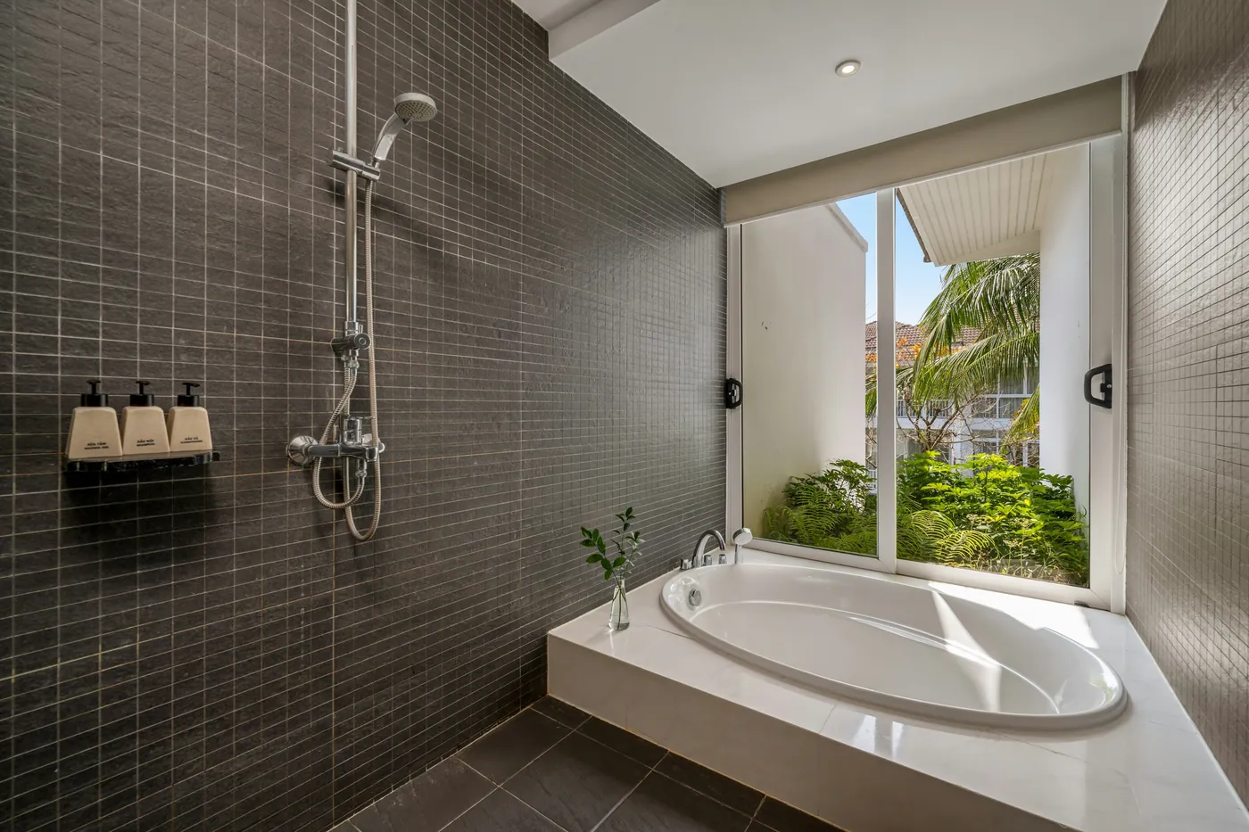 Fertig geplätteltes Bad mit Wanne, Dusche und grossem Fenster